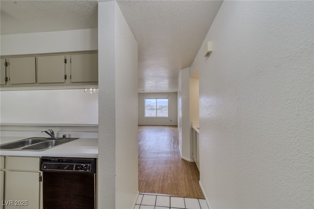 2040 Mesquite Ln Unit 203, Laughlin, NV 89029 - kitchen with dishwasher, a sink, light countertops, a textured wall, and baseboards