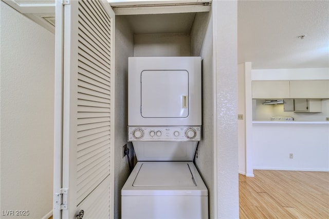 2040 Mesquite Ln Unit 203, Laughlin, NV 89029 - washroom with stacked washer / dryer, wood finished floors, and baseboards