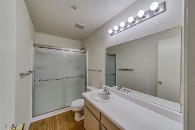 2040 Mesquite Ln Unit 203, Laughlin, NV 89029 - full bath featuring toilet, a stall shower, wood finished floors, vanity, and a textured ceiling