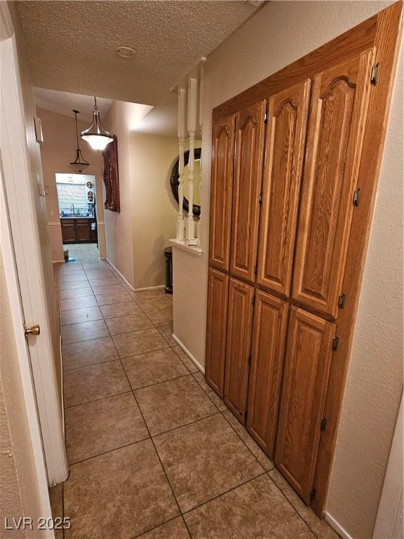 7104 Carrondale Way, Las Vegas, NV 89128 - corridor featuring light tile patterned floors and a textured ceiling