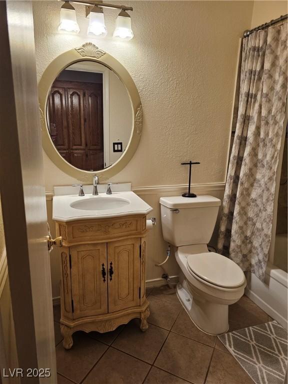 7104 Carrondale Way, Las Vegas, NV 89128 - full bath with a textured wall, toilet, tile patterned floors, vanity, and baseboards