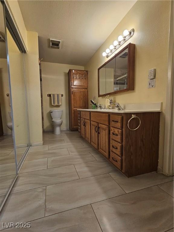 7104 Carrondale Way, Las Vegas, NV 89128 - full bathroom featuring toilet, vanity, and a shower with shower door