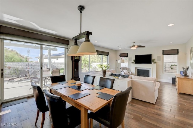 2440 Ping Dr, Henderson, NV 89074 - dining room featuring dark wood-style flooring, a glass covered fireplace, a ceiling fan, recessed lighting, and baseboards