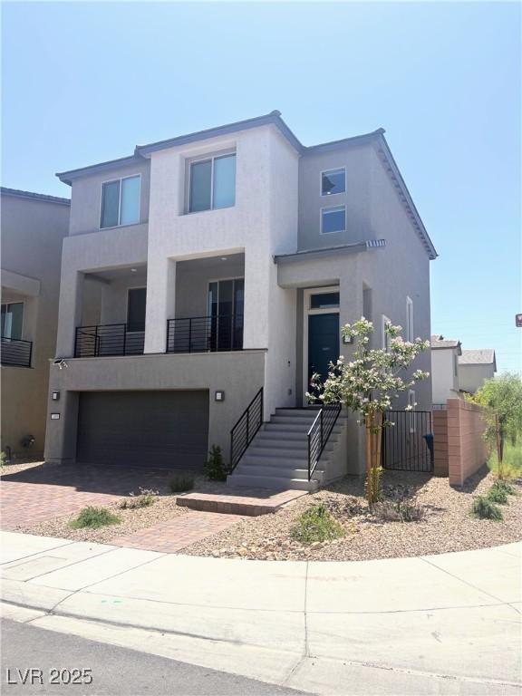 7499 Lodano Ave, Las Vegas, NV 89113 - contemporary home with an attached garage, stucco siding, and decorative driveway