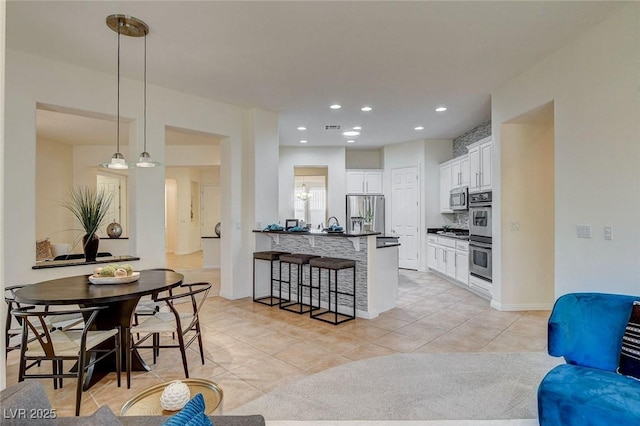 4845 Santo Romeo St, Las Vegas, NV 89135 - kitchen featuring stainless steel appliances, dark countertops, a breakfast bar area, a peninsula, and white cabinetry