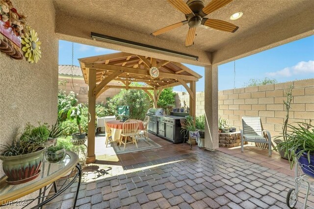 703 Shiva St, Las Vegas, NV 89178 - fenced backyard with ceiling fan, a patio area, a gazebo, a grill, and outdoor dining space