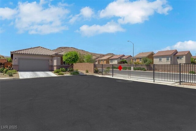 703 Shiva St, Las Vegas, NV 89178 - view of front of house featuring a residential view, a tile roof, stucco siding, an attached garage, and driveway