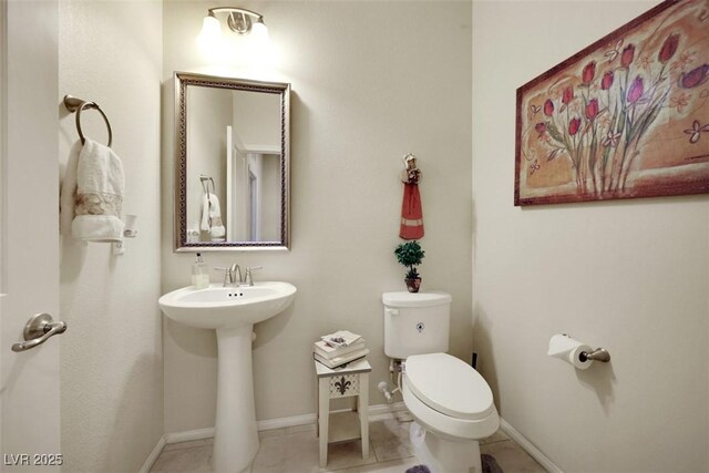 703 Shiva St, Las Vegas, NV 89178 - half bathroom featuring toilet, baseboards, tile patterned flooring, and a sink