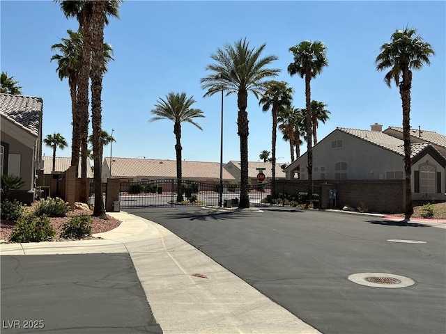 9753 Arrowcrest Ave, Las Vegas, NV 89147 - view of asphalt road featuring sidewalks, traffic signs, a gate, a gated entry, and curbs