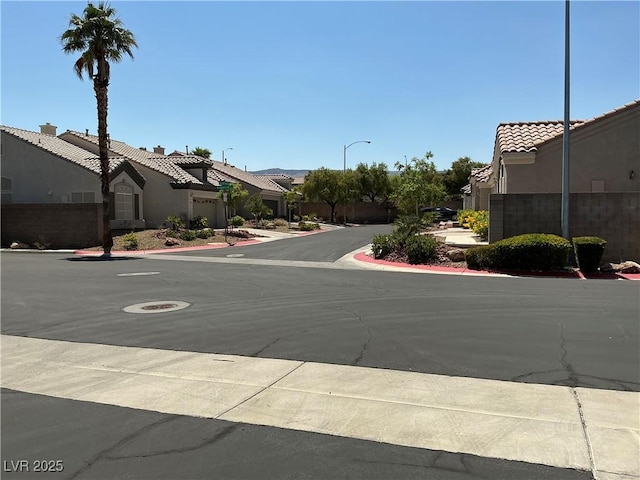 9753 Arrowcrest Ave, Las Vegas, NV 89147 - view of asphalt road with street lighting, sidewalks, a residential view, and curbs