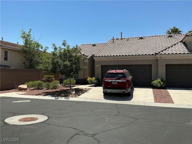 9753 Arrowcrest Ave, Las Vegas, NV 89147 - view of front facade with a garage, concrete driveway, a tile roof, and stucco siding