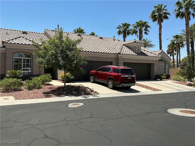 9753 Arrowcrest Ave, Las Vegas, NV 89147 - view of front of home with an attached garage, a tile roof, concrete driveway, and stucco siding