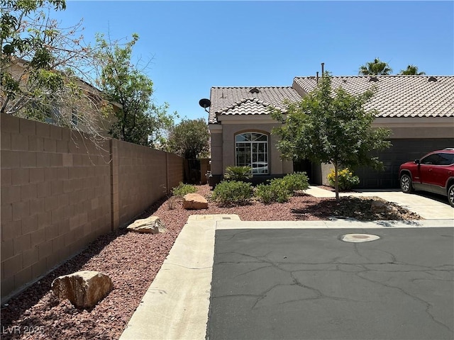 9753 Arrowcrest Ave, Las Vegas, NV 89147 - view of front facade featuring a tiled roof, an attached garage, driveway, and stucco siding