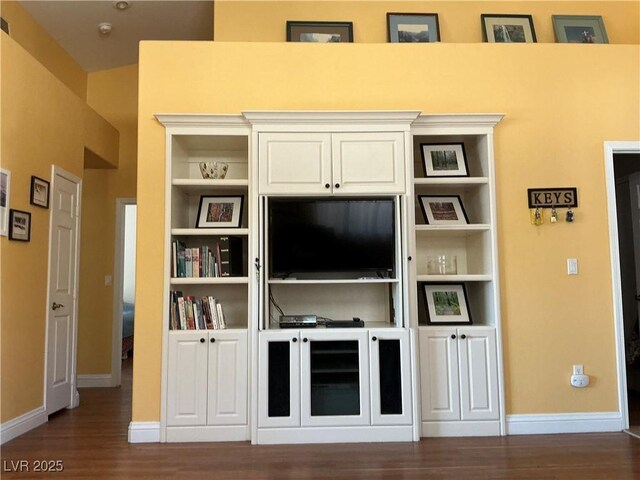 9753 Arrowcrest Ave, Las Vegas, NV 89147 - unfurnished living room with dark wood-style floors, baseboards, and built in shelves