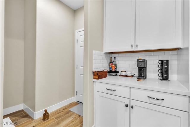 741 Monroe Hill Pl, Henderson, NV 89011 - bar with baseboards, light wood finished floors, and tasteful backsplash