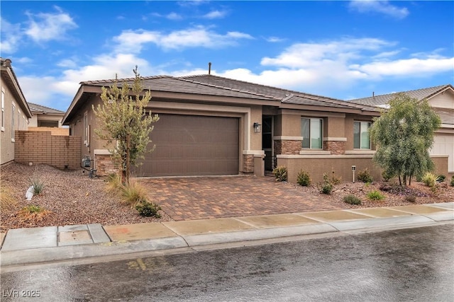 741 Monroe Hill Pl, Henderson, NV 89011 - view of front facade featuring stucco siding, stone siding, an attached garage, decorative driveway, and a tile roof
