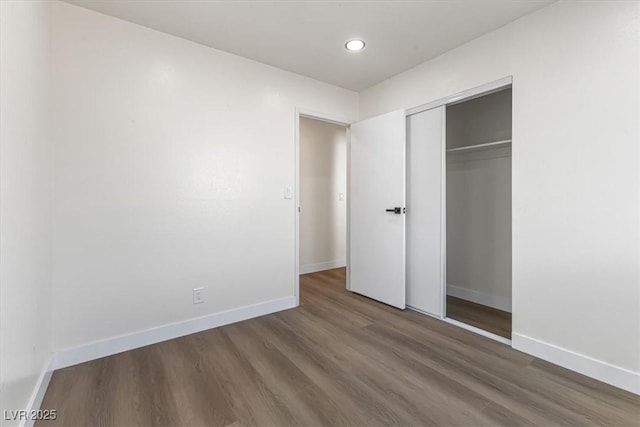 704 Slayton Dr, Las Vegas, NV 89107 - unfurnished bedroom with wood finished floors, baseboards, a closet, and recessed lighting