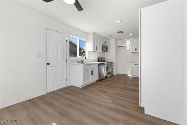 704 Slayton Dr, Las Vegas, NV 89107 - kitchen featuring stainless steel appliances, light countertops, ceiling fan, white cabinetry, and recessed lighting