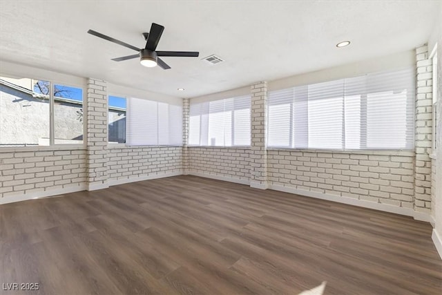 704 Slayton Dr, Las Vegas, NV 89107 - empty room with brick wall, dark wood-type flooring, plenty of natural light, a ceiling fan, and recessed lighting