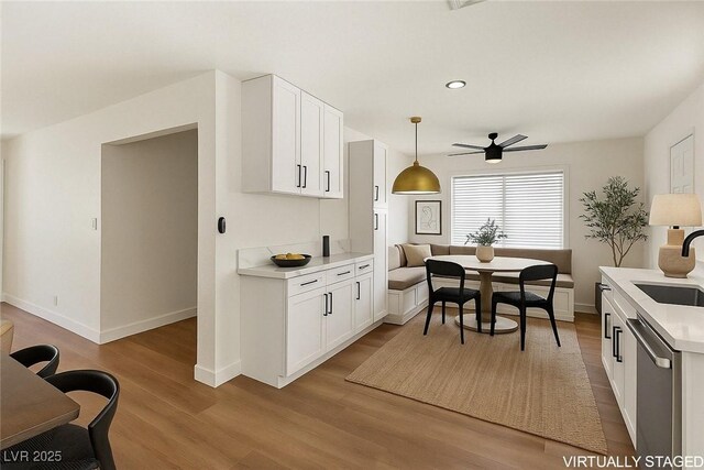 704 Slayton Dr, Las Vegas, NV 89107 - kitchen with dishwasher, wood finished floors, light countertops, a sink, and baseboards