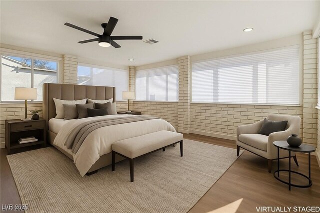 704 Slayton Dr, Las Vegas, NV 89107 - bedroom featuring wood finished floors, brick wall, and a ceiling fan