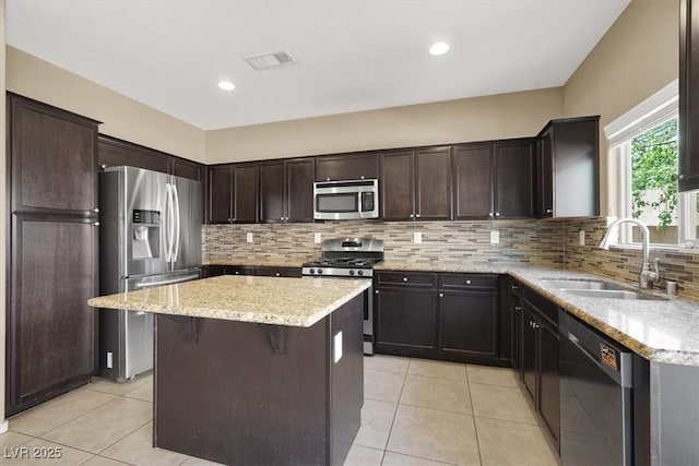 7931 Mineral Peak St, Las Vegas, NV 89166 - kitchen with stainless steel appliances, a sink, light tile patterned floors, a kitchen island, and recessed lighting