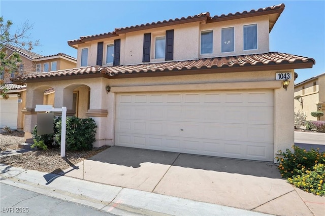 1043 Monte De Oro Ave, Las Vegas, NV 89183 - mediterranean / spanish home featuring a garage, a tiled roof, driveway, and stucco siding