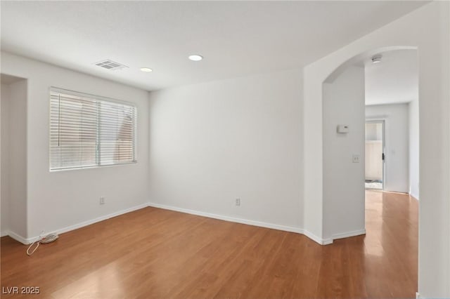 1043 Monte De Oro Ave, Las Vegas, NV 89183 - spare room featuring arched walkways, light wood-style flooring, recessed lighting, baseboards, and a smoke detector