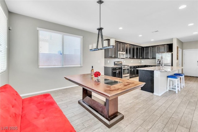 7624 Mallard Bay Ave, Las Vegas, NV 89179 - kitchen with stainless steel appliances, healthy amount of natural light, light wood-type flooring, backsplash, and recessed lighting