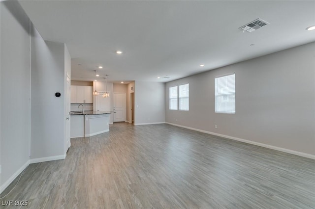 3270 Palindrome Ave, Henderson, NV 89044 - unfurnished living room with light wood-type flooring, recessed lighting, baseboards, and a sink