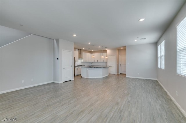 3270 Palindrome Ave, Henderson, NV 89044 - unfurnished living room with recessed lighting, light wood-type flooring, baseboards, and a sink