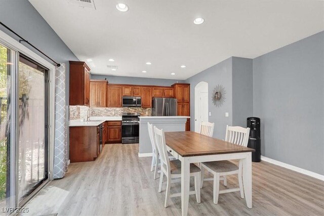10845 Drake Ridge Ave, Las Vegas, NV 89166 - dining room with arched walkways, light wood-style floors, baseboards, and recessed lighting