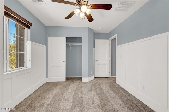 10845 Drake Ridge Ave, Las Vegas, NV 89166 - unfurnished bedroom featuring carpet floors, a decorative wall, a ceiling fan, and multiple closets