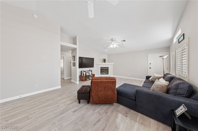 8316 Joseph Cary Ct, Las Vegas, NV 89145 - living area with ceiling fan, vaulted ceiling, light wood-style flooring, baseboards, and a tiled fireplace