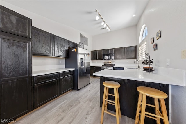 8316 Joseph Cary Ct, Las Vegas, NV 89145 - kitchen with stainless steel appliances, a sink, a kitchen bar, and light countertops