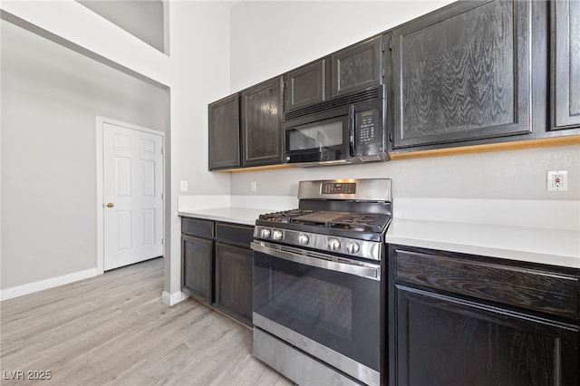 8316 Joseph Cary Ct, Las Vegas, NV 89145 - kitchen featuring stainless steel gas stove, black microwave, light wood-type flooring, light countertops, and baseboards