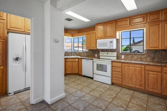 633 5th St, Boulder City, NV 89005 - kitchen with white appliances, a sink, decorative backsplash, and light tile patterned floors