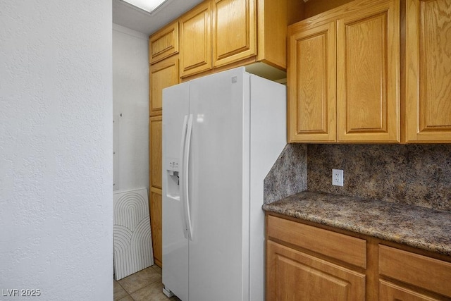 633 5th St, Boulder City, NV 89005 - kitchen with white fridge with ice dispenser, tasteful backsplash, dark countertops, and light tile patterned flooring