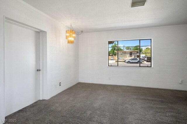 633 5th St, Boulder City, NV 89005 - carpeted empty room with a chandelier, ornamental molding, a textured ceiling, and brick wall