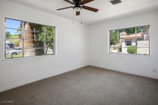 633 5th St, Boulder City, NV 89005 - carpeted empty room featuring healthy amount of natural light, brick wall, a ceiling fan, and crown molding