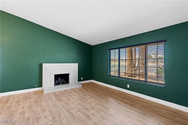 1655 E Hacienda Ave, Las Vegas, NV 89119 - unfurnished living room featuring vaulted ceiling, wood finished floors, and baseboards