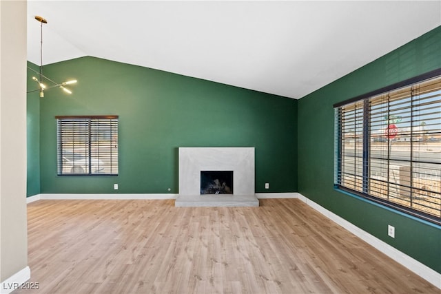 1655 E Hacienda Ave, Las Vegas, NV 89119 - unfurnished living room featuring lofted ceiling, healthy amount of natural light, wood finished floors, and baseboards