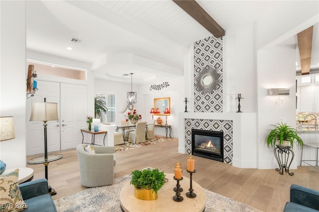 10404 Long Leaf Pl, Las Vegas, NV 89134 - living area featuring light wood-style flooring, beam ceiling, and a tiled fireplace