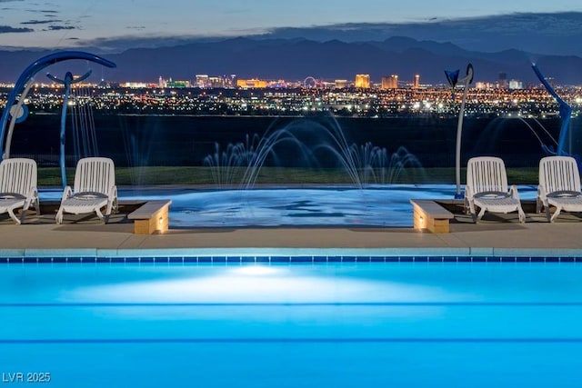 338 Taylor St, Henderson, NV 89015 - pool at night with a view of city lights, a community pool, and a patio area