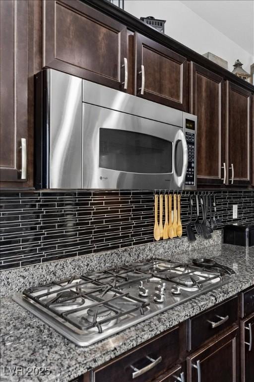 6857 Stone Tower Ct, Las Vegas, NV 89149 - kitchen featuring stainless steel appliances, light stone counters, decorative backsplash, and dark brown cabinetry