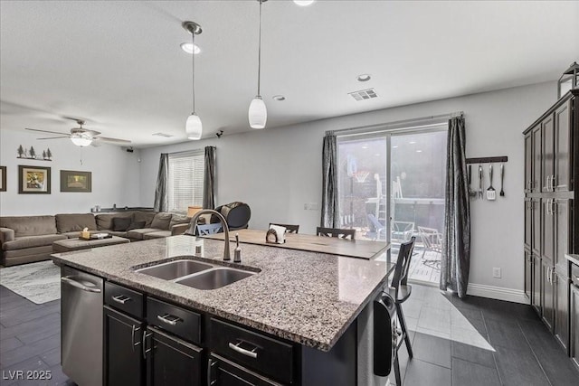 6857 Stone Tower Ct, Las Vegas, NV 89149 - kitchen featuring a sink, a center island with sink, a ceiling fan, hanging light fixtures, and open floor plan