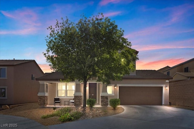 6857 Stone Tower Ct, Las Vegas, NV 89149 - view of front of home featuring stone siding, concrete driveway, a garage, stucco siding, and a tiled roof