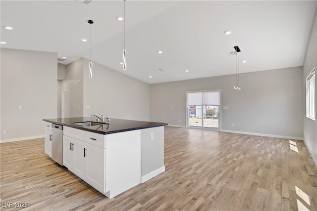 2130 Revere St, North Las Vegas, NV 89030 - kitchen featuring dark countertops, light wood-type flooring, stainless steel dishwasher, a center island with sink, and recessed lighting