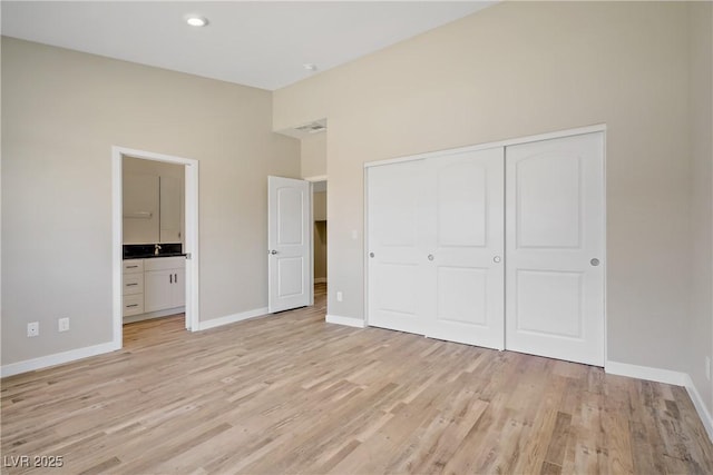 2130 Revere St, North Las Vegas, NV 89030 - unfurnished bedroom featuring a closet, light wood finished floors, a towering ceiling, and connected bathroom