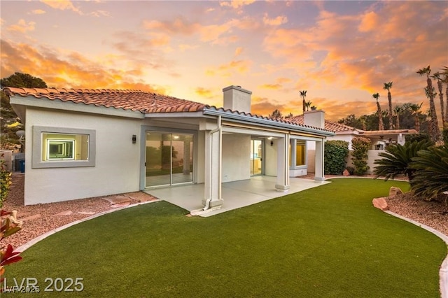 1613 Shadow Rock Dr, Las Vegas, NV 89117 - rear view of house featuring a chimney, a patio area, a lawn, stucco siding, and a tile roof